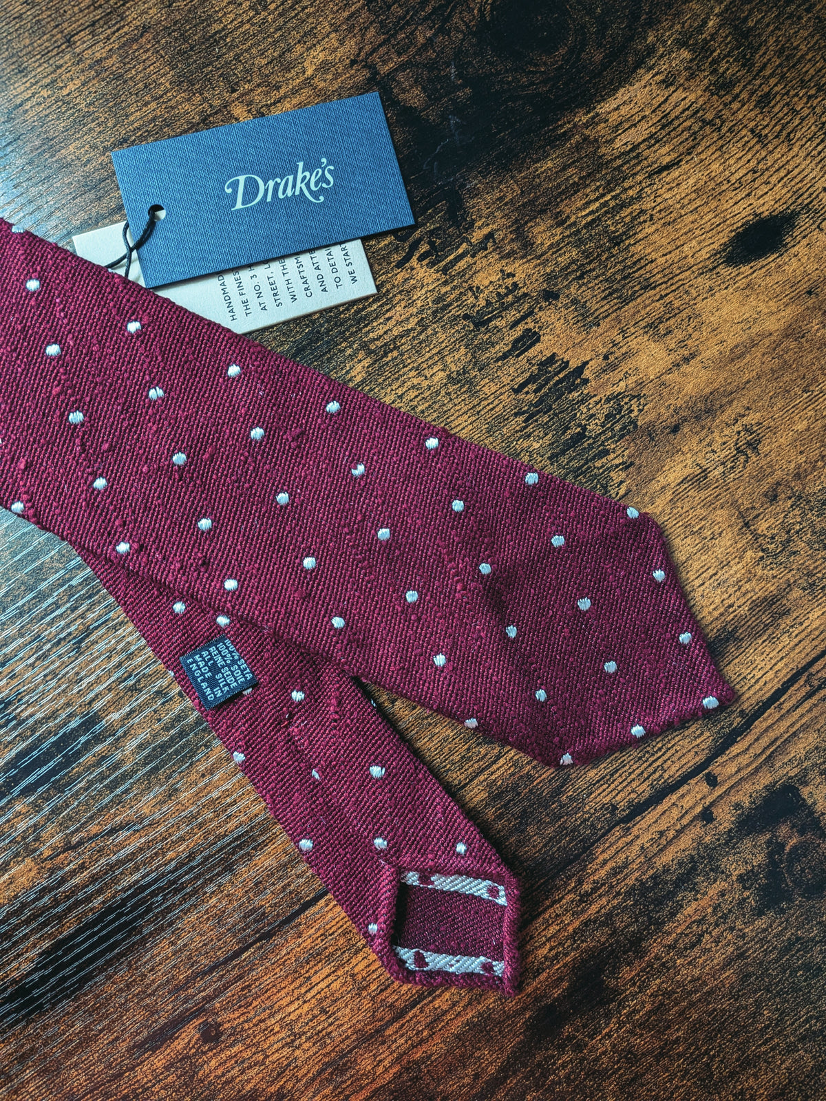 Drake's burgundy handmade polka dot hand rolled silk tie detail view 2